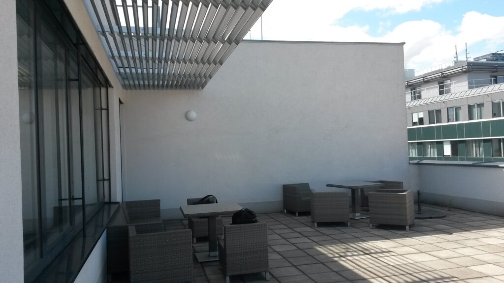 Im Bild ist eine Schul-Terrasse ohne Begrünung zu sehen.